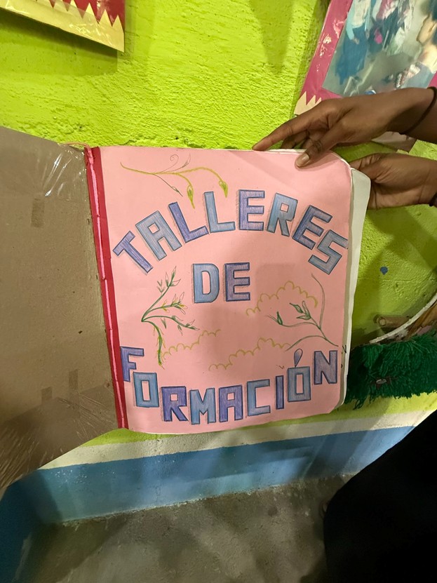 A pink, handwritten workbook in Spanish.