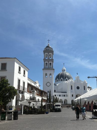 White and grey buildings against a blue sky.