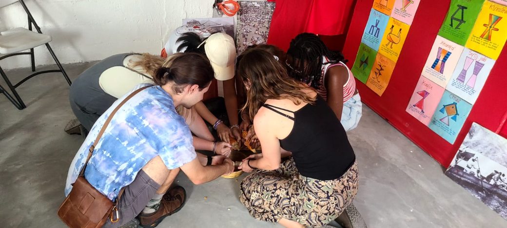 A group of people huddled together and crouched on the ground.