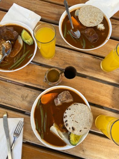 Dishes and cups full of food on a table.