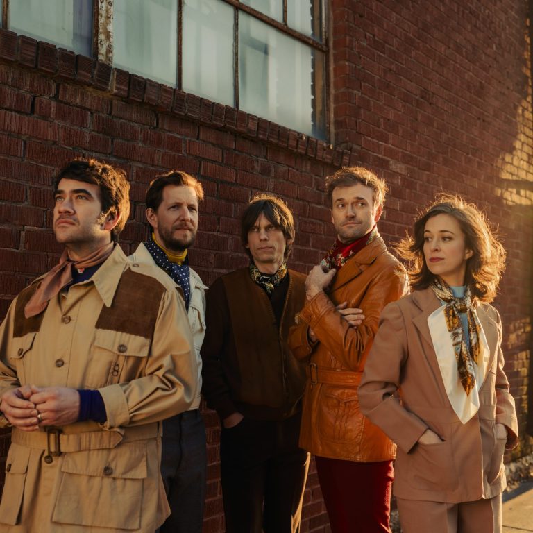punch brothers promotion includes all five members in the sunset against a brick wall looking in different directions.