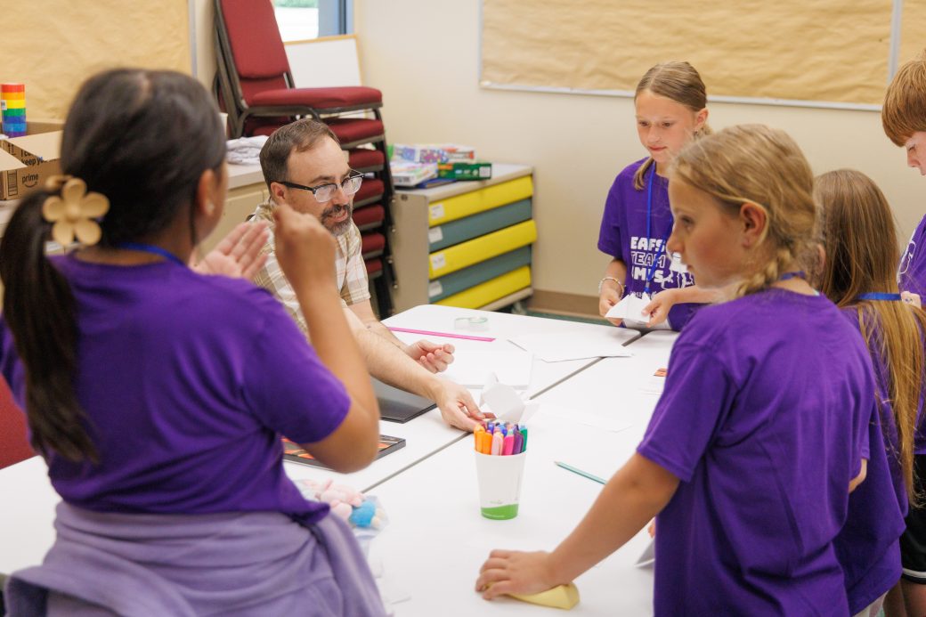 Students listen to teacher explain how to play game