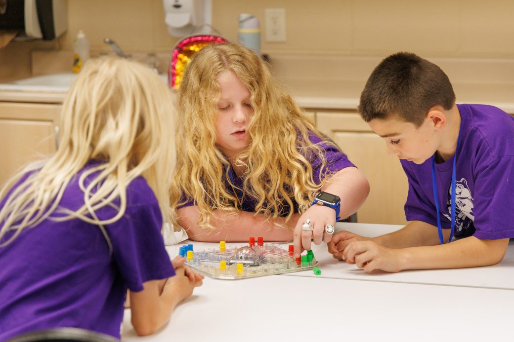 Group of kids at table playing board game