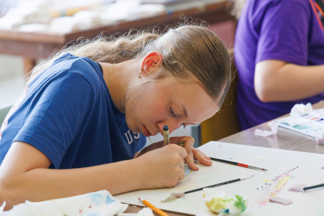 Junior high student painting at art camp