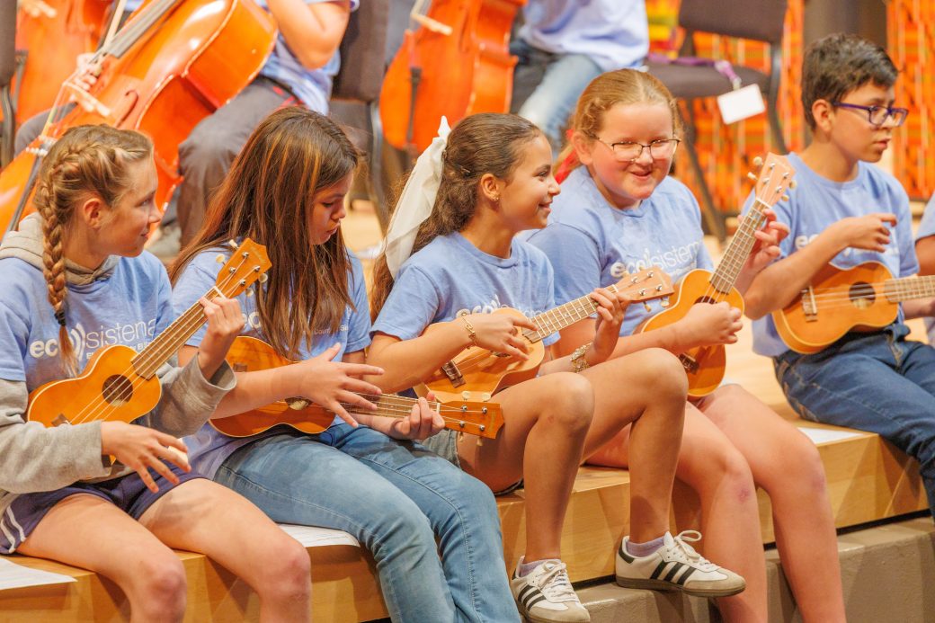 Students smiling playing ukele
