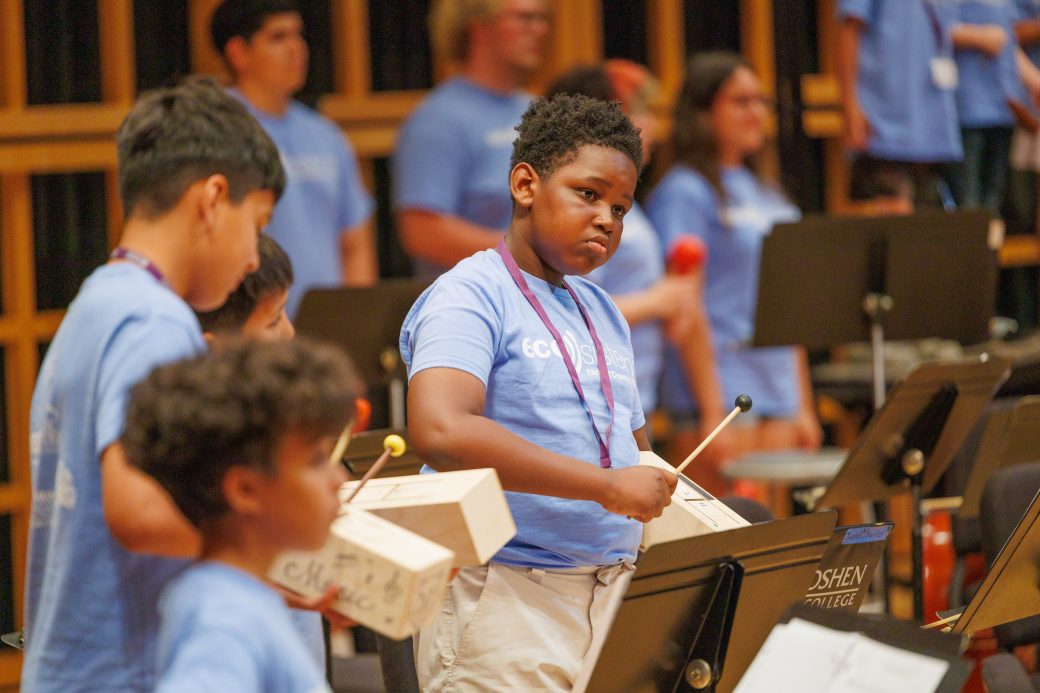 Close up of student playing instrument with box
