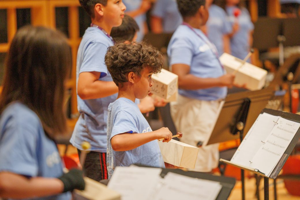 Close up of student playing instrument with box