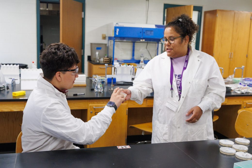 Teacher handing camper lab project