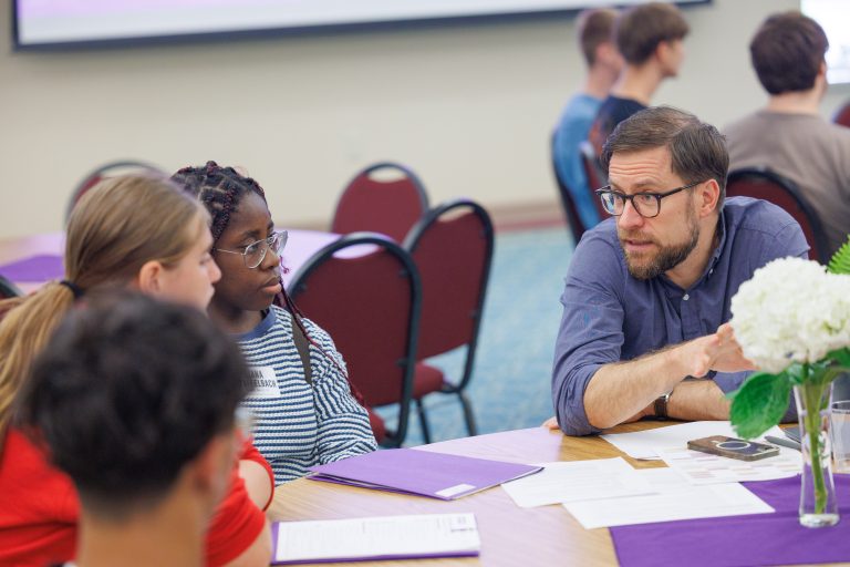 Academic advisor is advising incoming students around a table