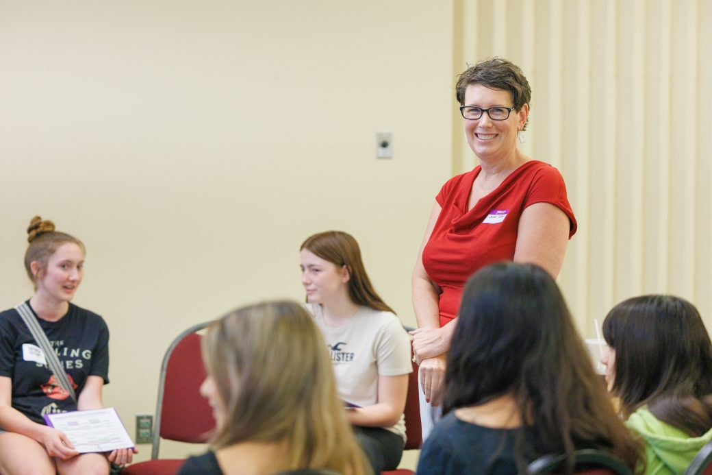 Nursing academic advisor is smiling at the camera while her new incoming students introduce themselves