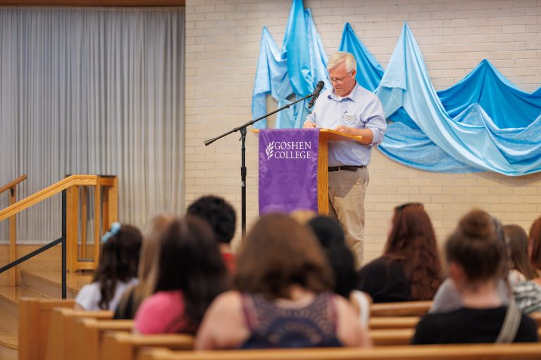 Speaker talks to incoming class of students and families in chapel