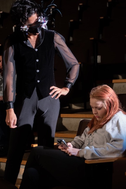 A male performer standing female performer sitting on stage