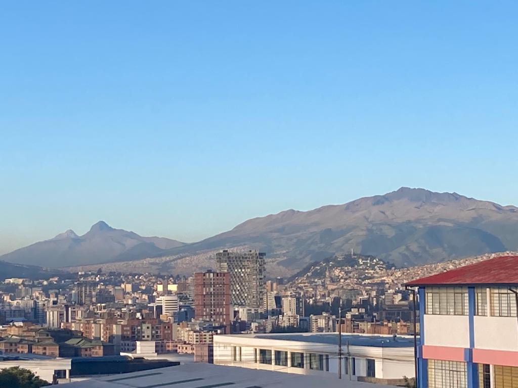 A panoramic view of green mountains under a blue sky.