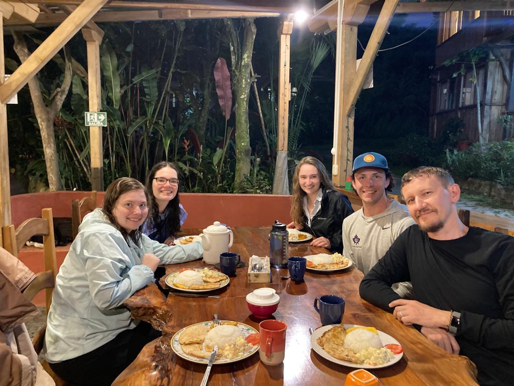 A group gathered at a table enjoying dinner together at night.