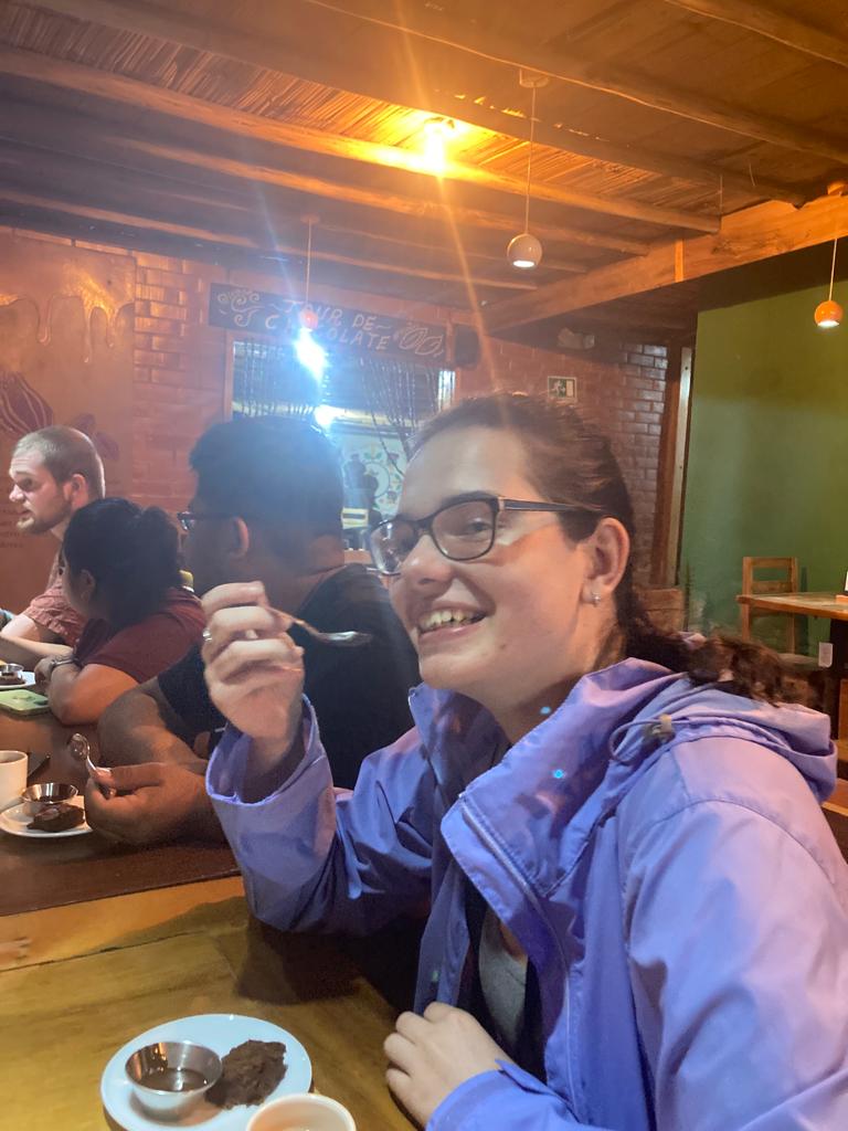 Two people laughing together at a table at night.