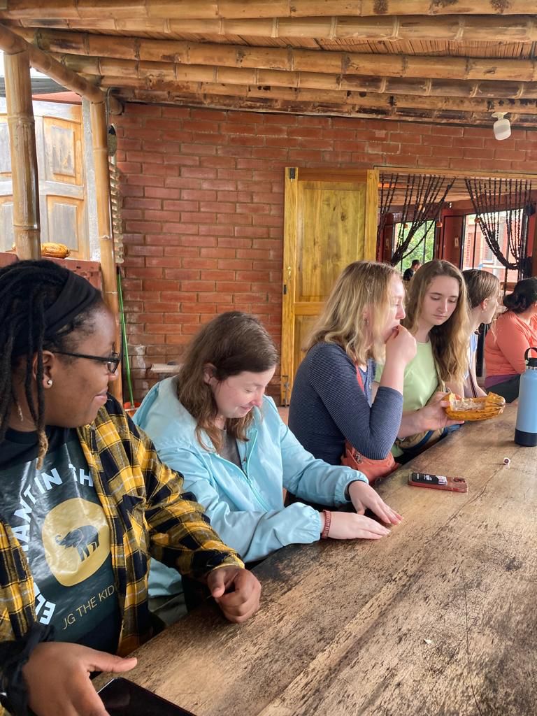 People sitting together at a long wooden table indoors.