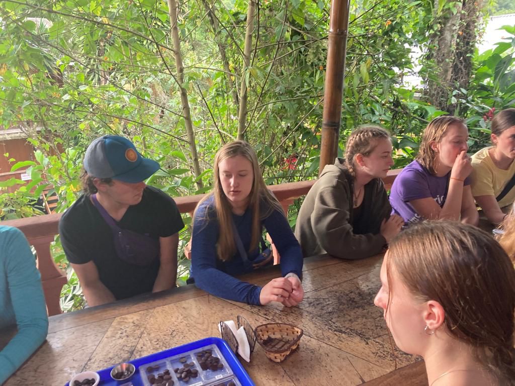 People seated at a table examining and tasting cacao products.