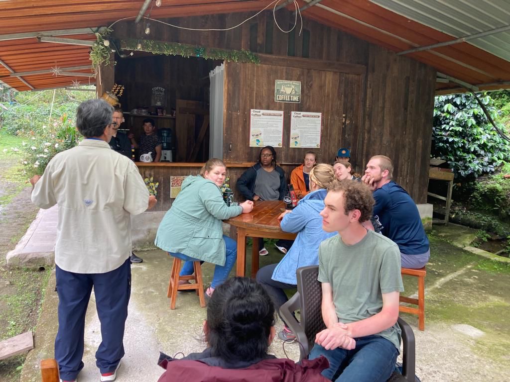Students sitting and talking together on an outdoor patio.