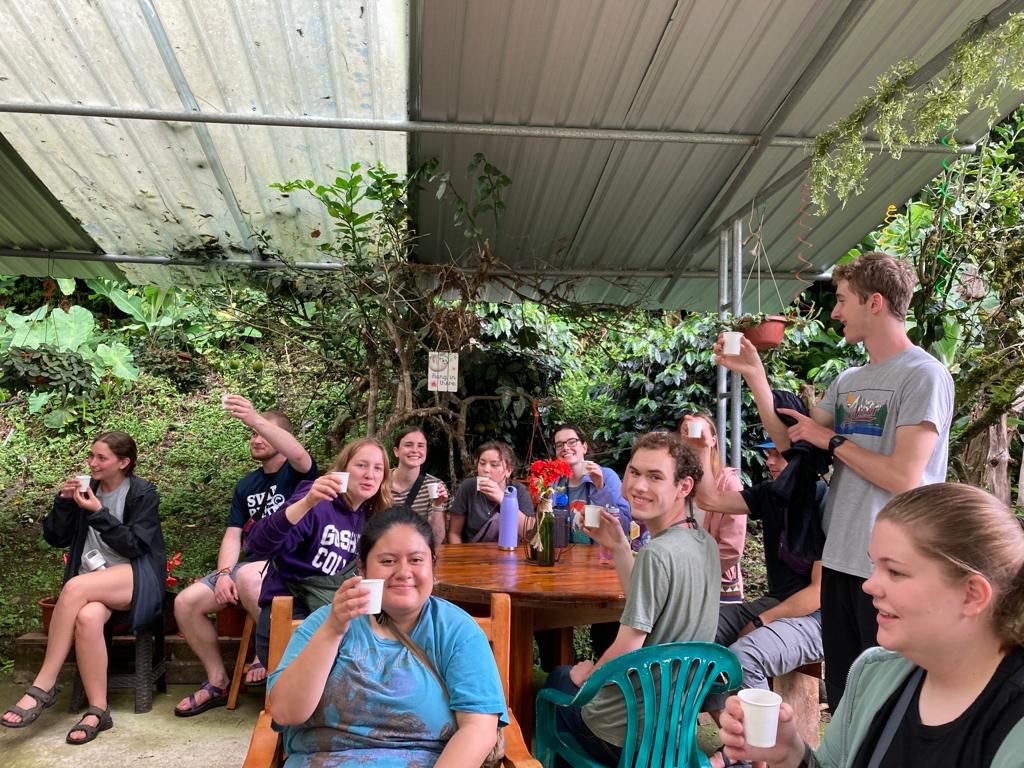 Students gathered inside a farm building talking together.