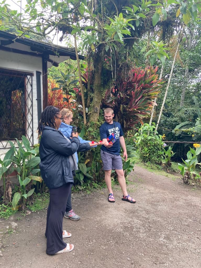 Two students talking on a path surrounded by lush greenery.