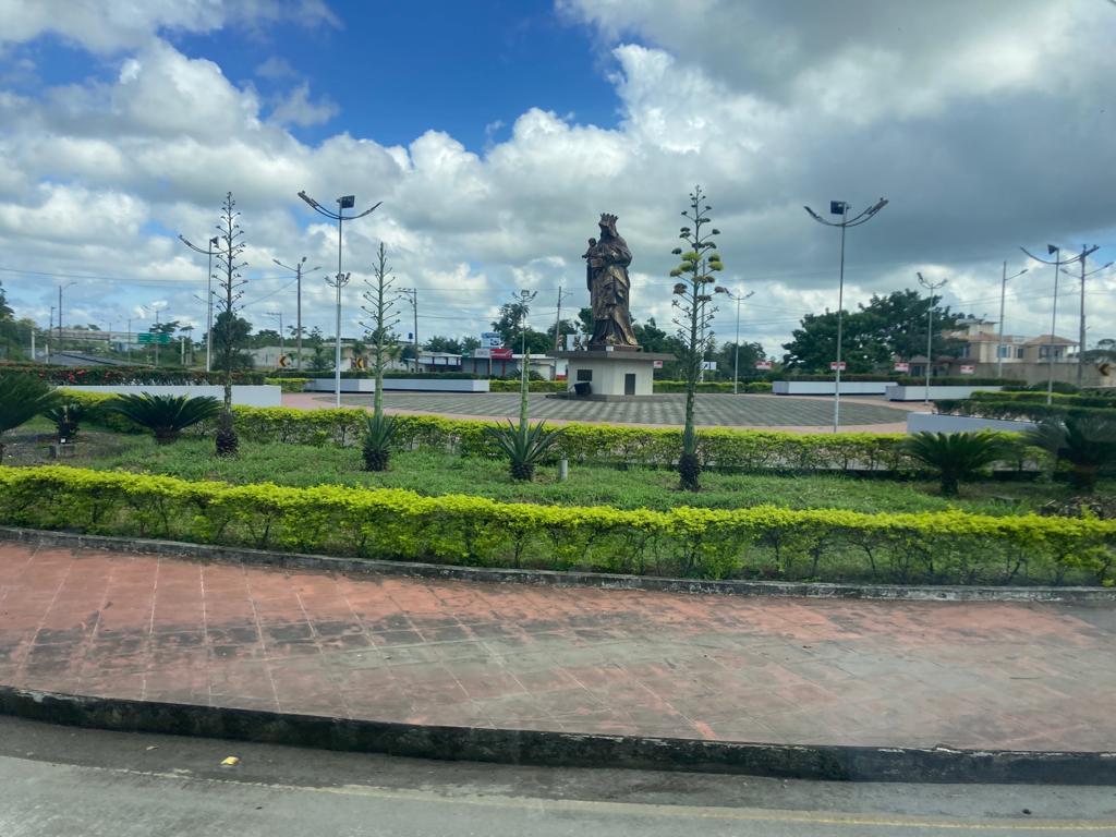 A town roundabout with a central statue and landscaped garden.