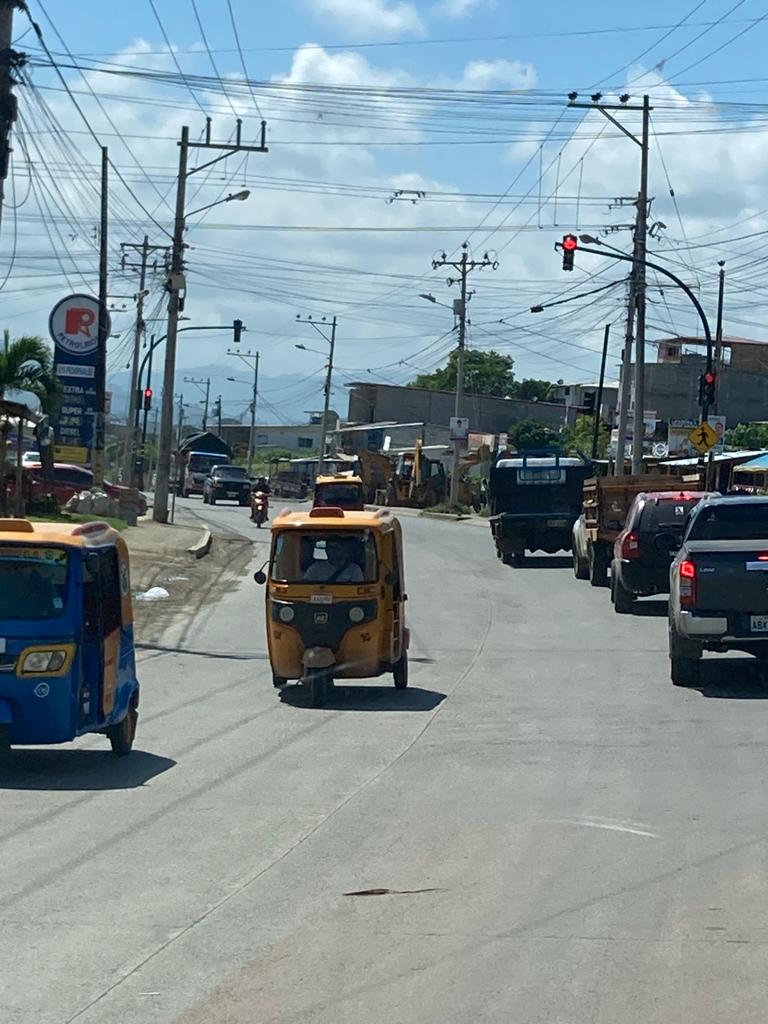 A street busy with blue auto-rickshaws and other traffic.