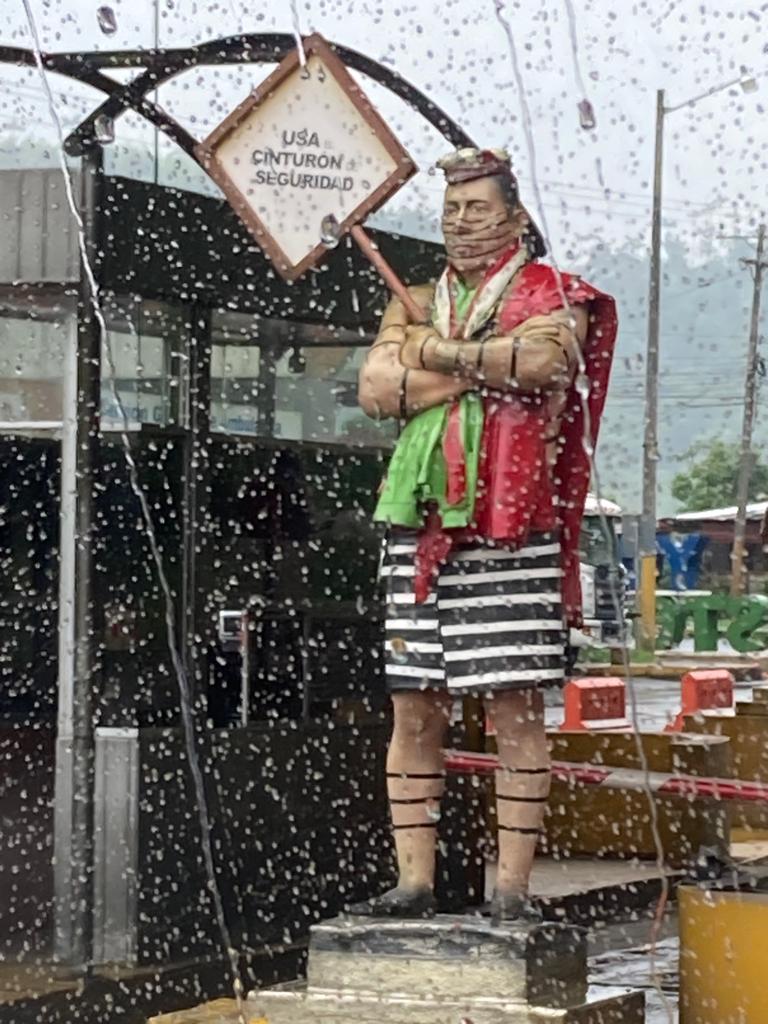 A costumed warrior figure displayed at a roadside stand.
