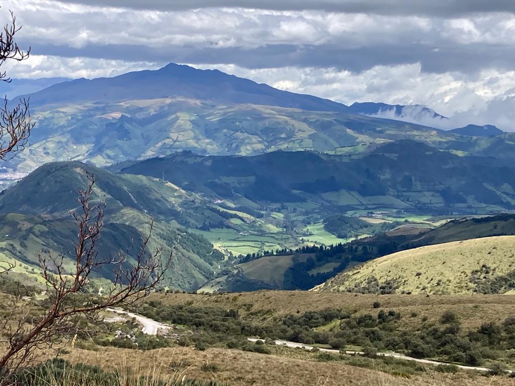 A sweeping view of Andean mountains and green valleys.
