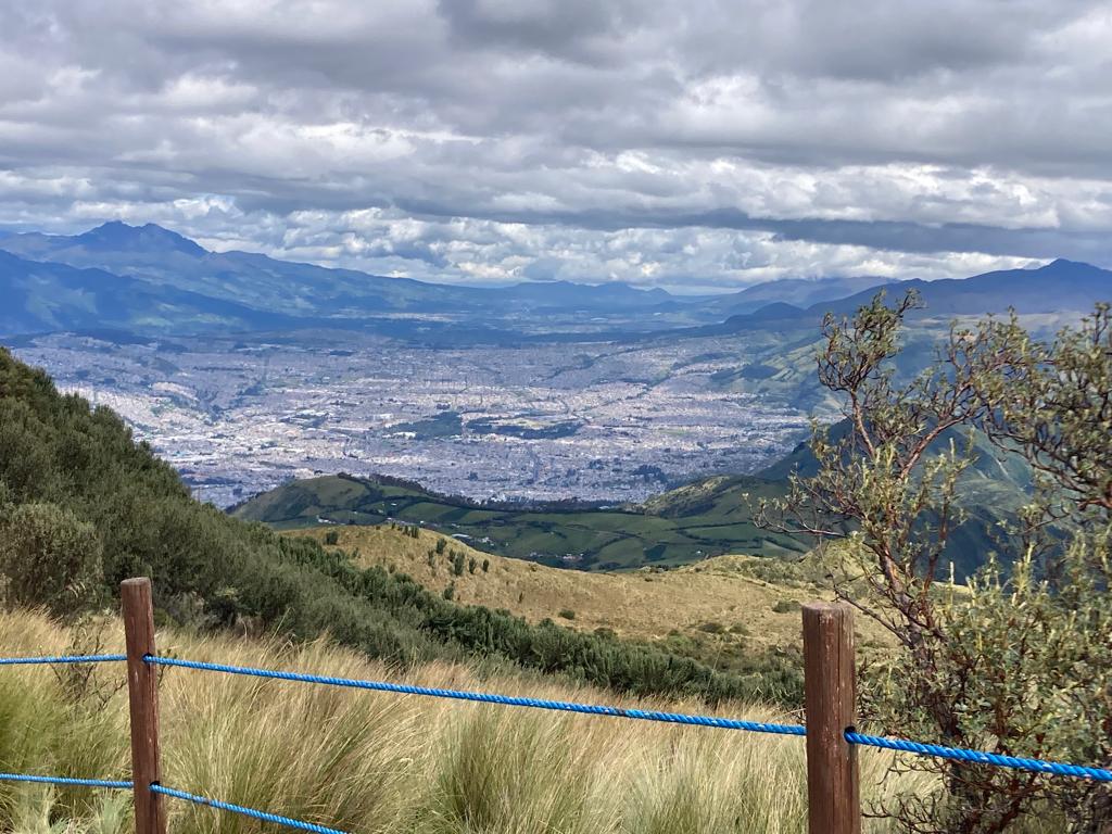 A panoramic view of a city spreading across a mountain valley.
