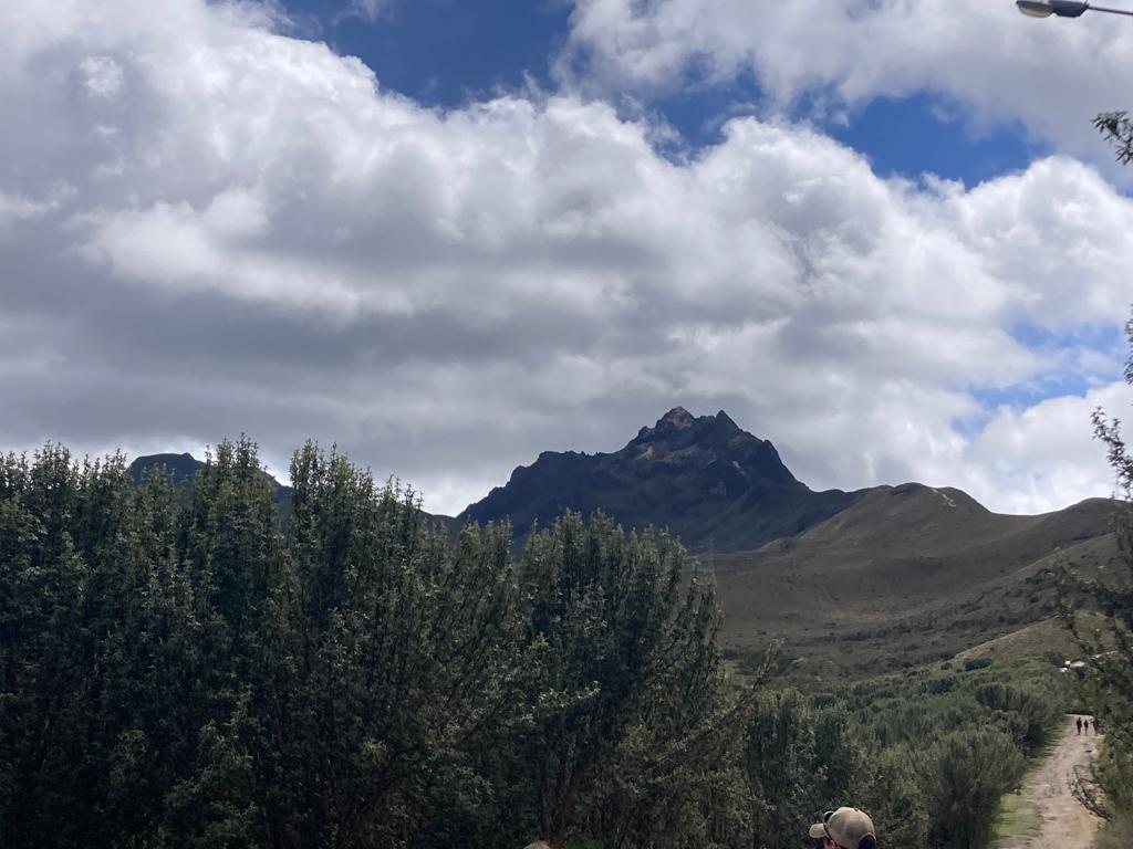 A jagged mountain summit seen from a hiking trail.
