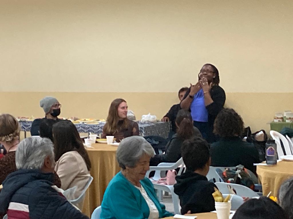 Attendees seated and chatting at a community event.
