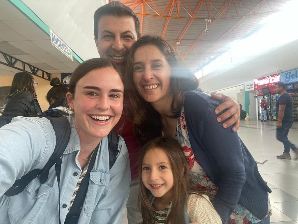 A student taking a selfie with a host family at a station.
