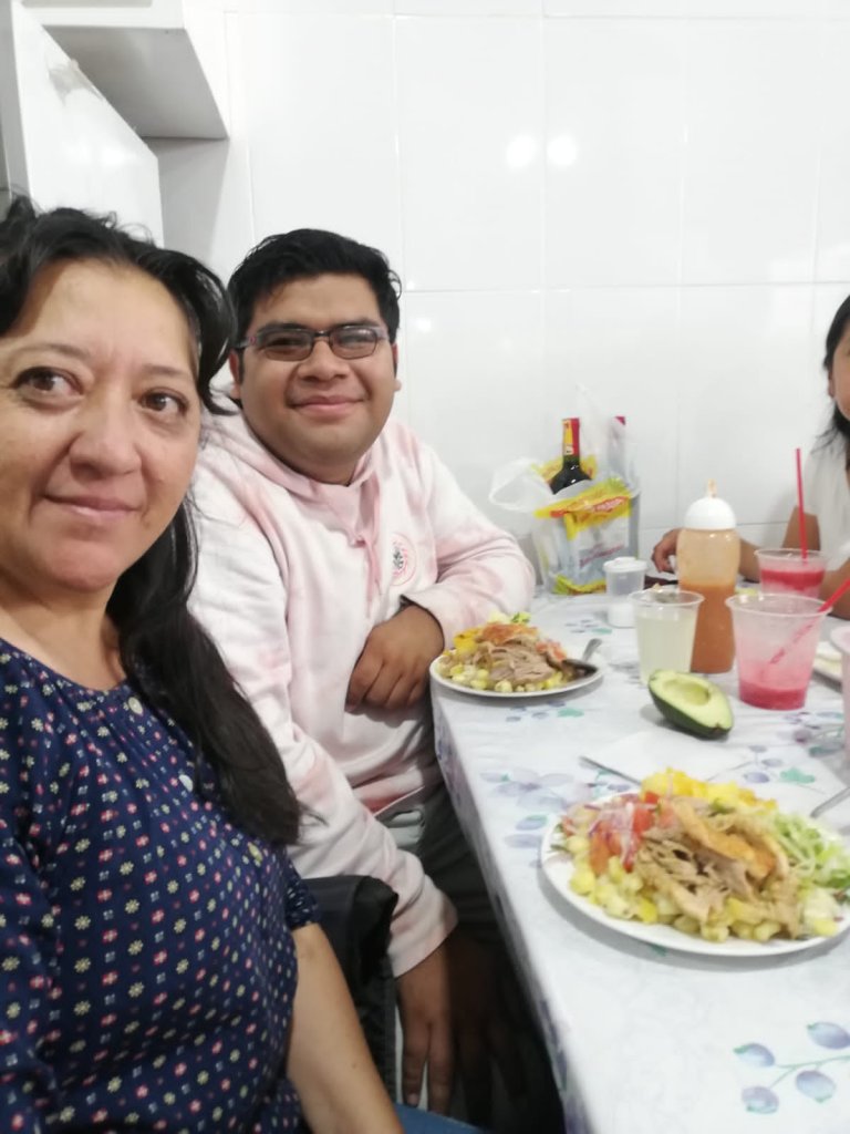 A selfie of a student with a host family sharing a meal.
