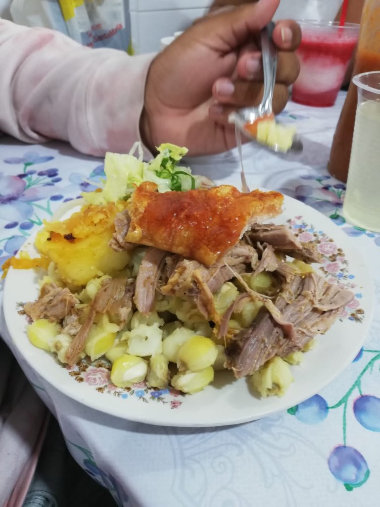A plate of a traditional meat, potato, and corn dish.
