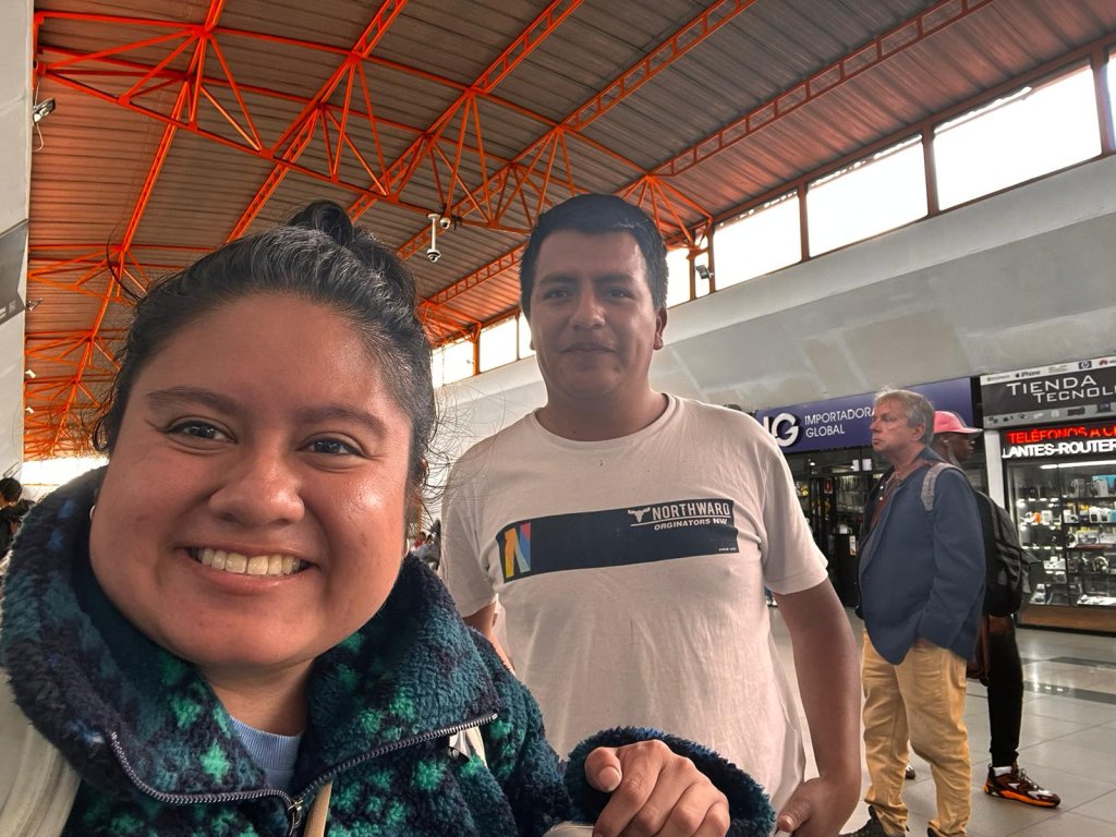 A selfie of a student with a host family member indoors.

