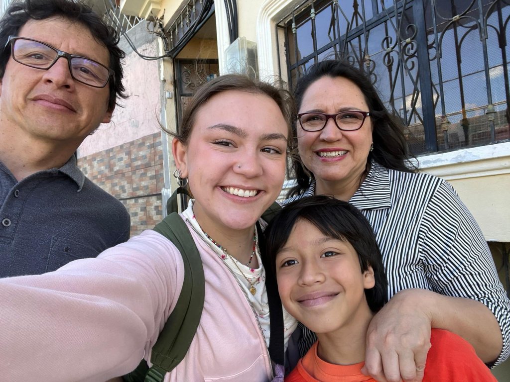 A student posing for a selfie with a host family.
