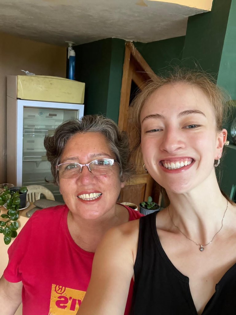 A student and a host family member smiling in a selfie.
