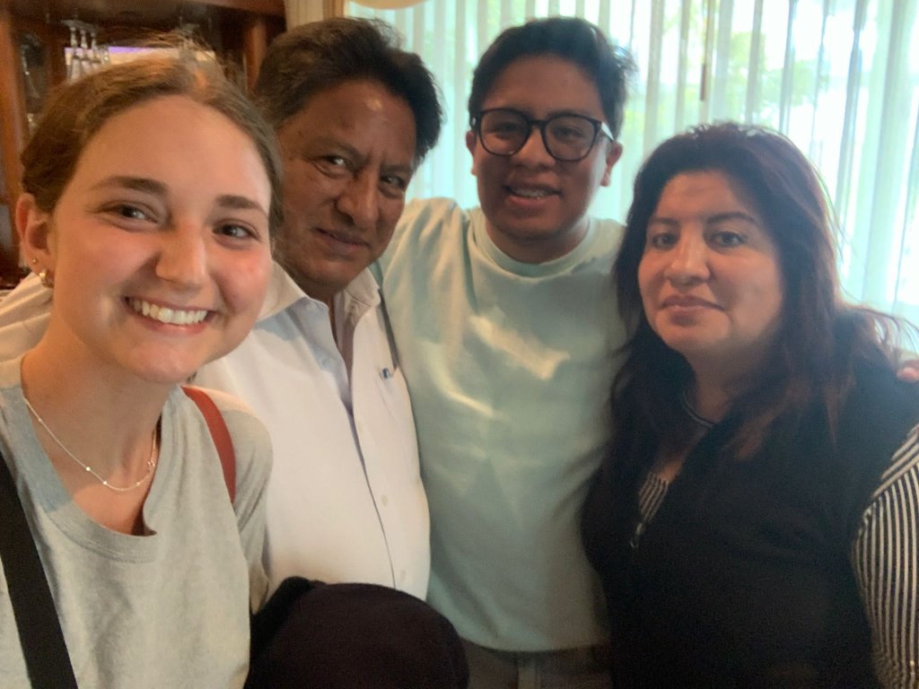 A student taking a group selfie with a host family.
