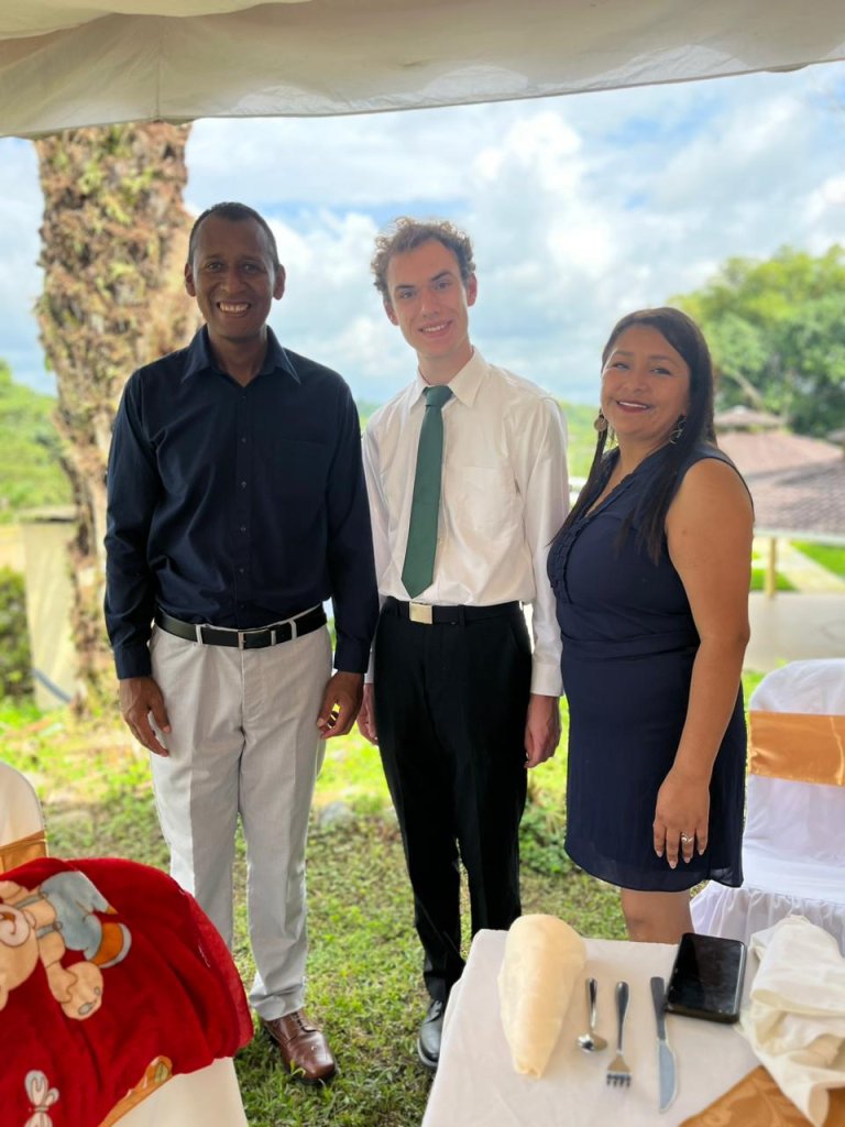 A student posing with a host family outdoors.
