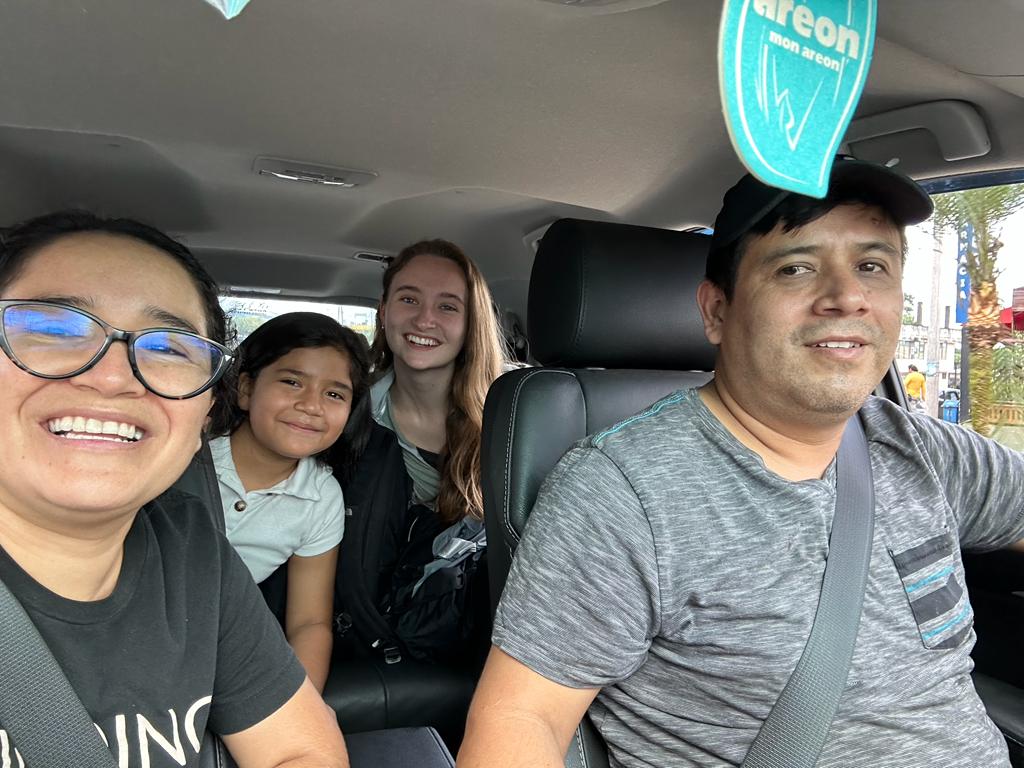 A selfie of students and a host family inside a car.
