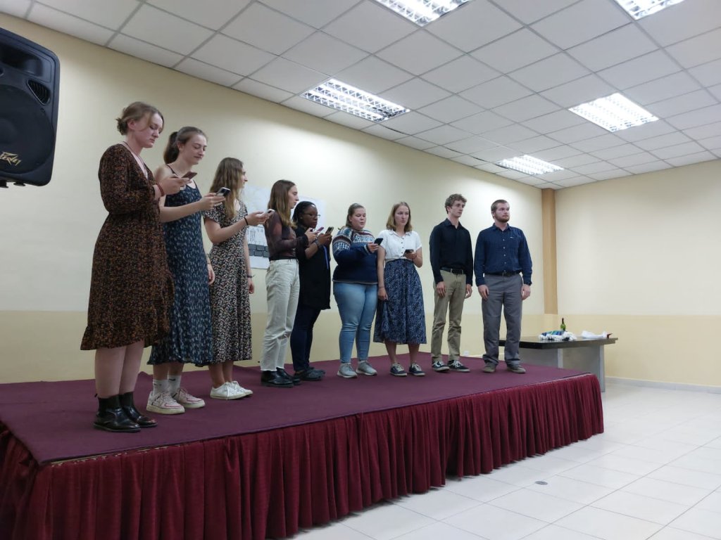 A group of students standing together on stage performing.
