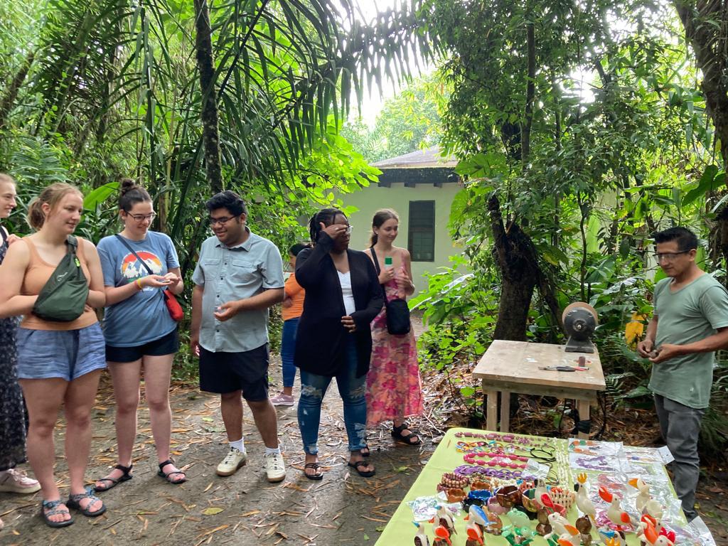 A group of students gathered outdoors in a lush garden.
