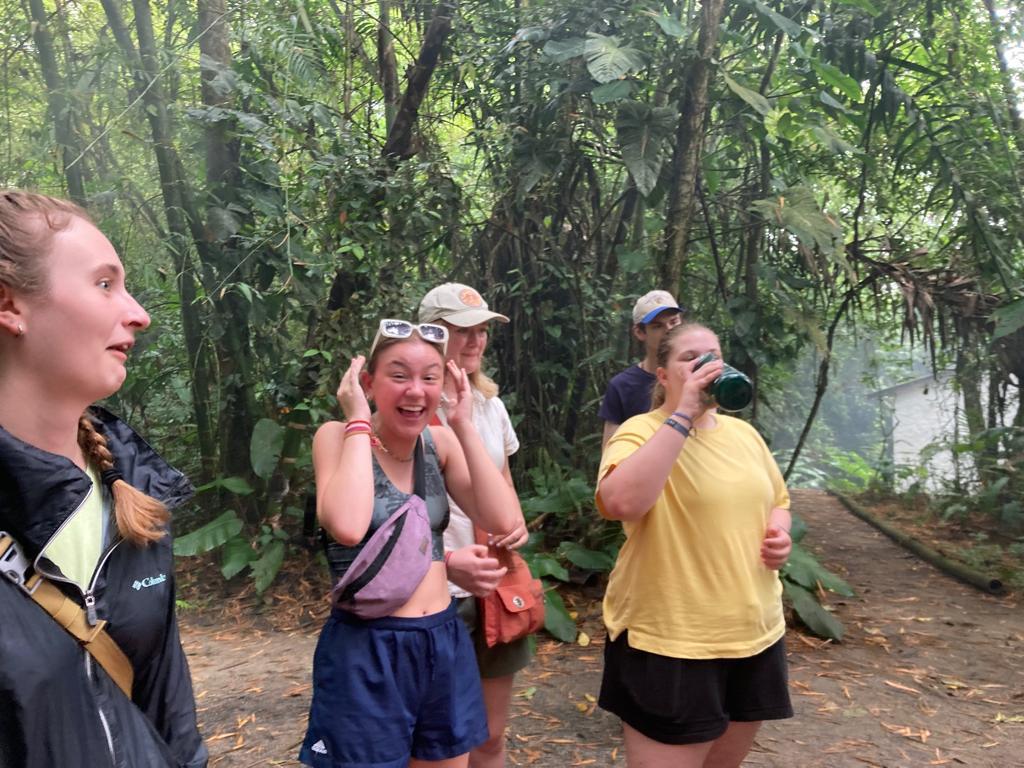 Students laughing and chatting together on a jungle path.
