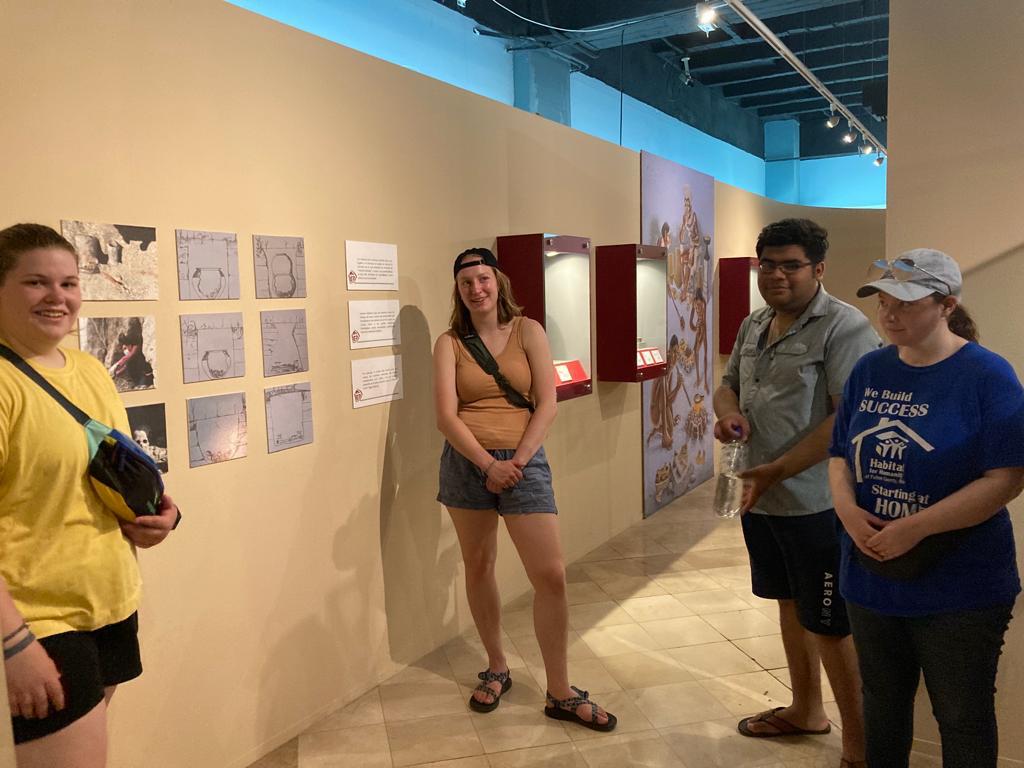 A group of students viewing framed exhibits in a gallery.