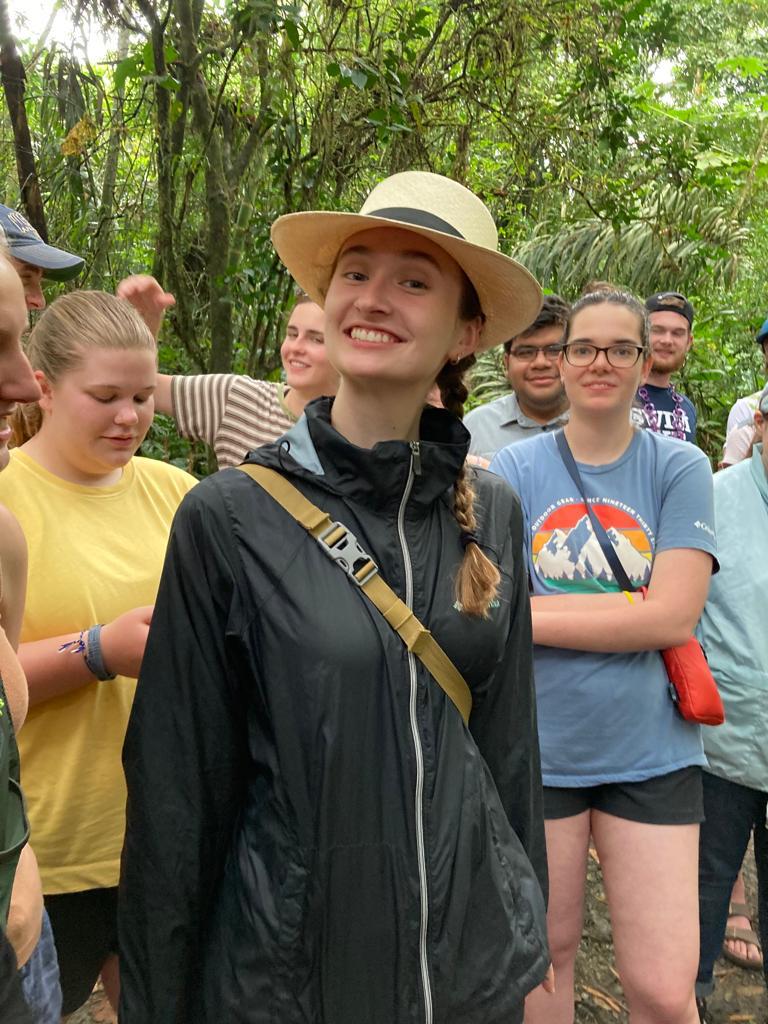 A smiling woman wearing a straw hat among the group.
