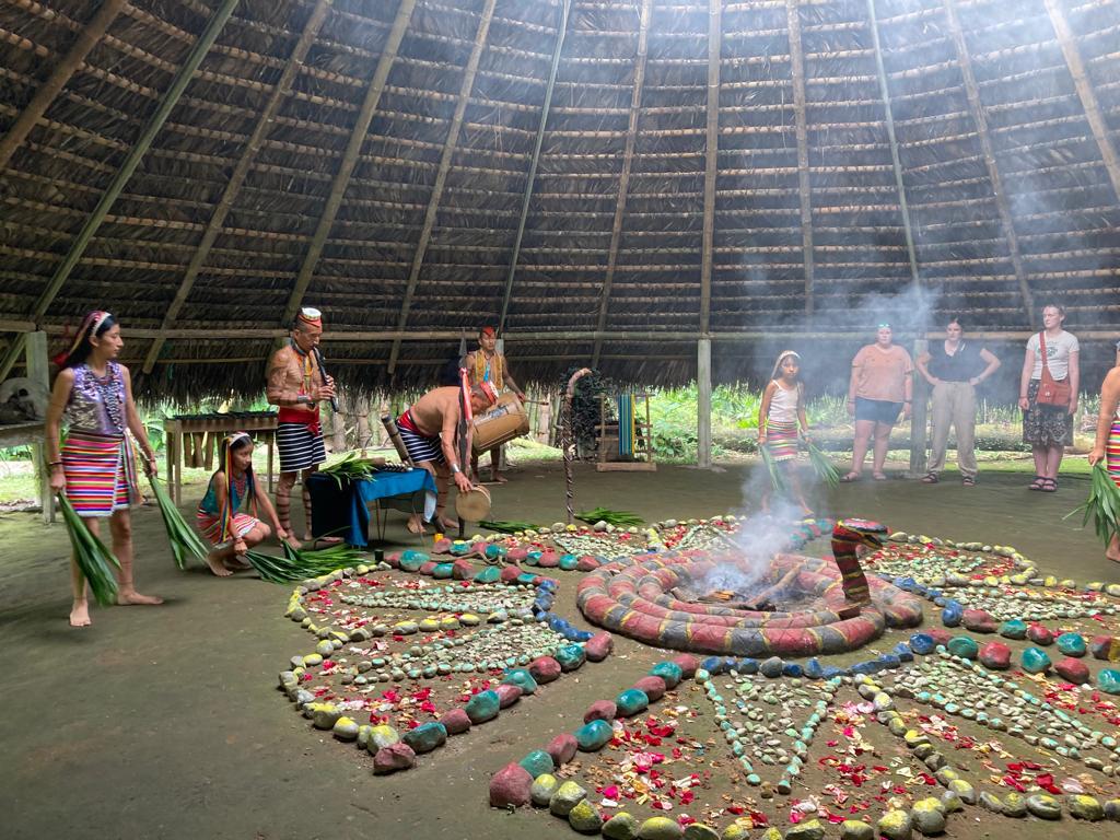A cultural ceremony around a decorated altar with incense smoke.
