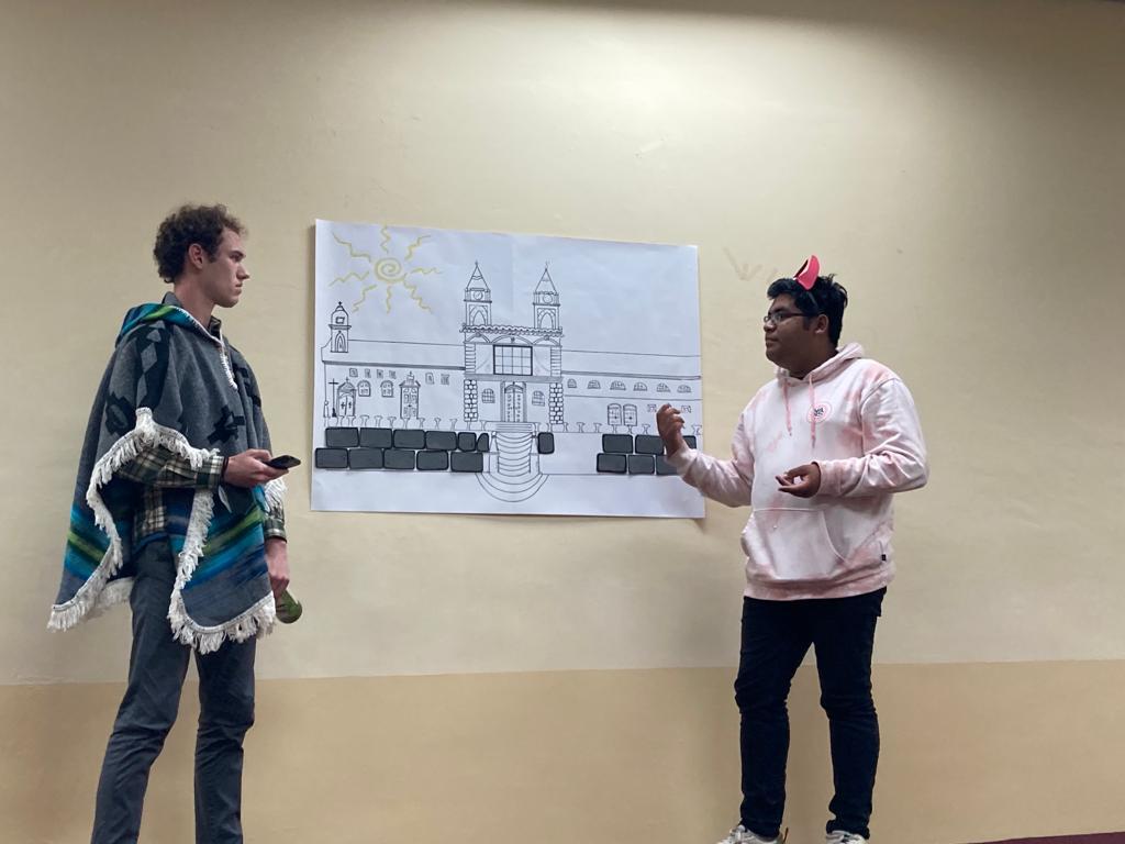 Two students conversing during a skit on stage.
