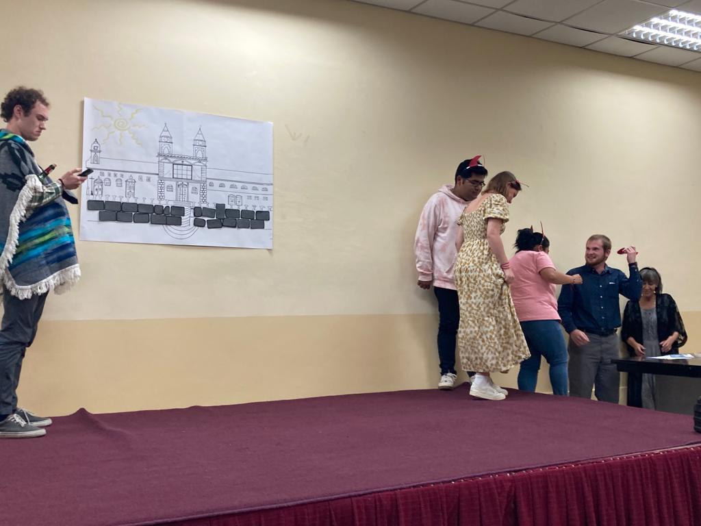 Students acting out a presentation on stage.
