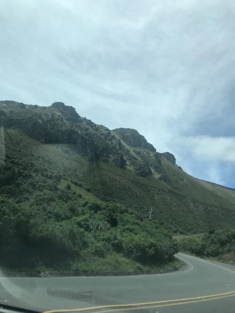 A forested mountain ridge viewed from a car window.
